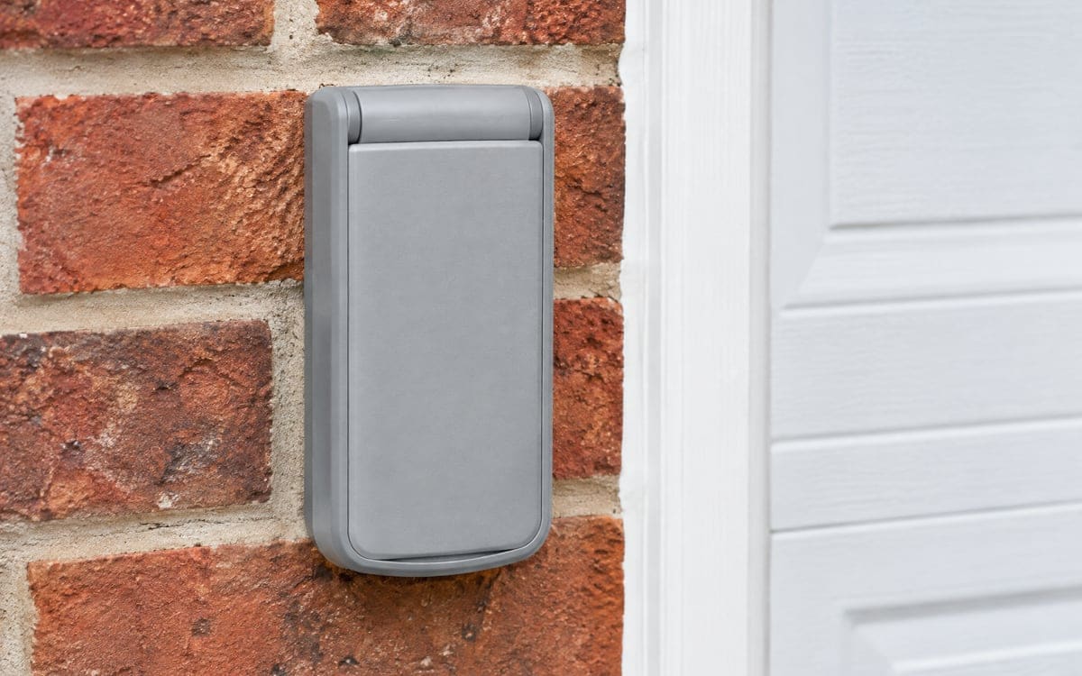 Garage door opener repair takes in outdoor keypads like this one, mounted on brick with its cover closed.