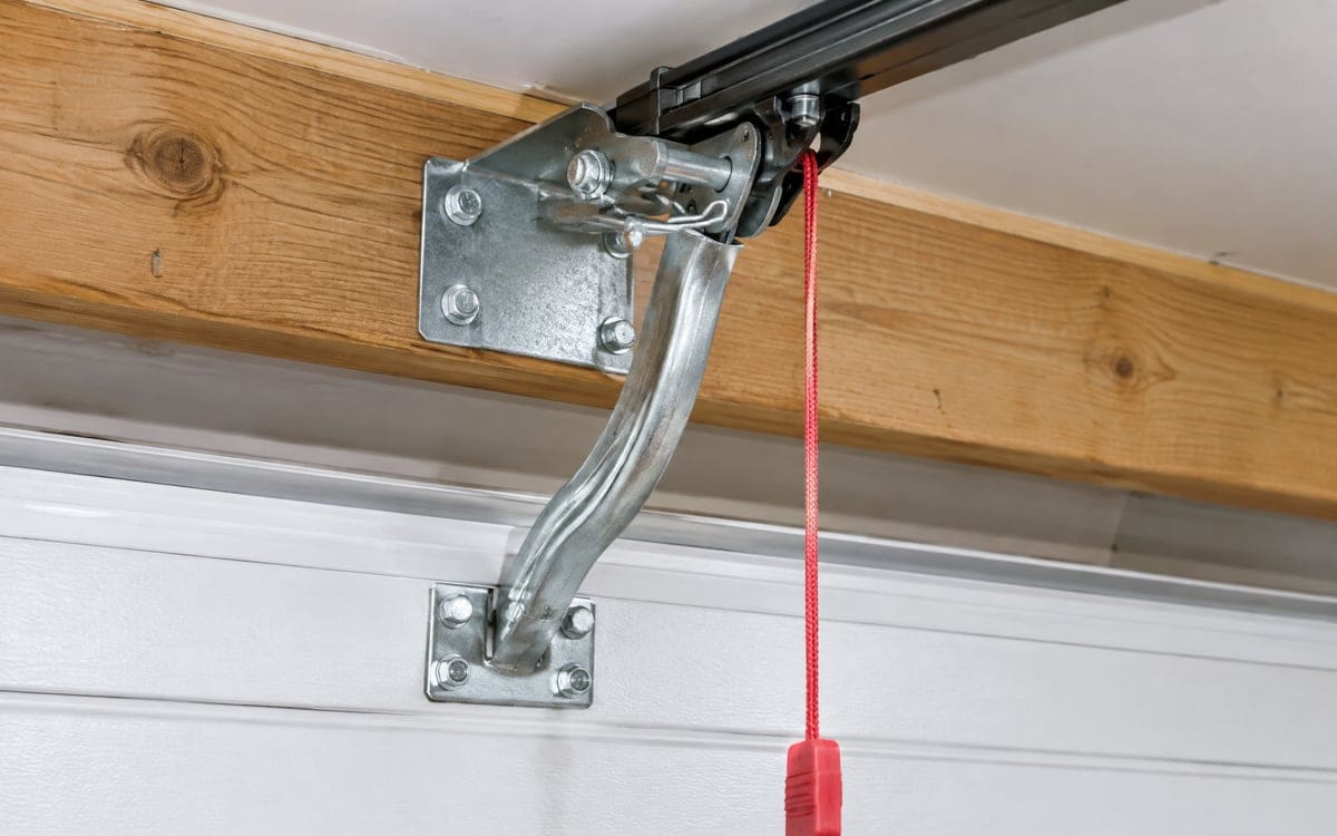 The opener rail pinned to its header bracket above the door, with the door arm running down to the top section.