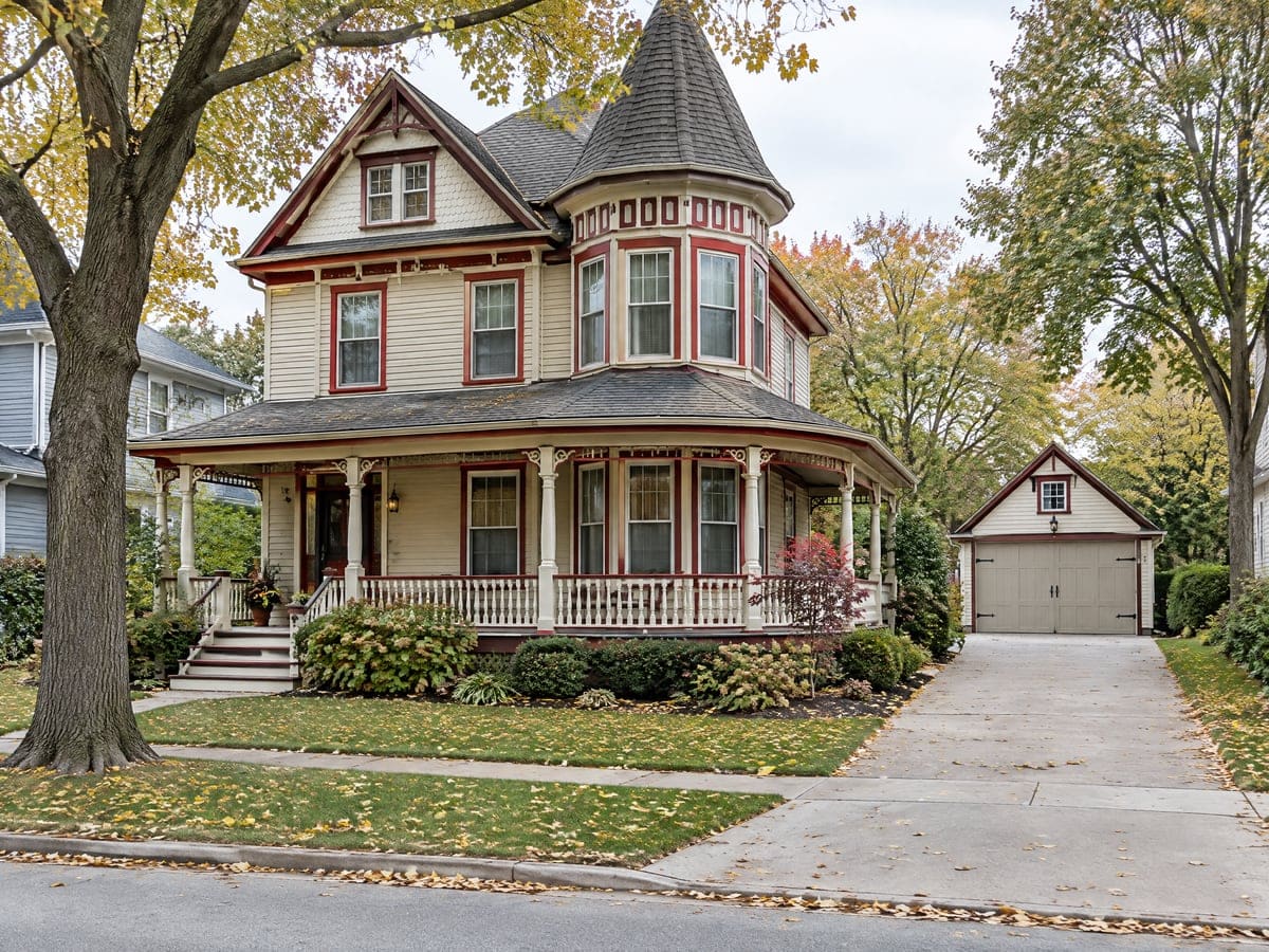 Garage door repair for older homes: a Queen Anne frame house with a detached carriage house and a painted wood door.