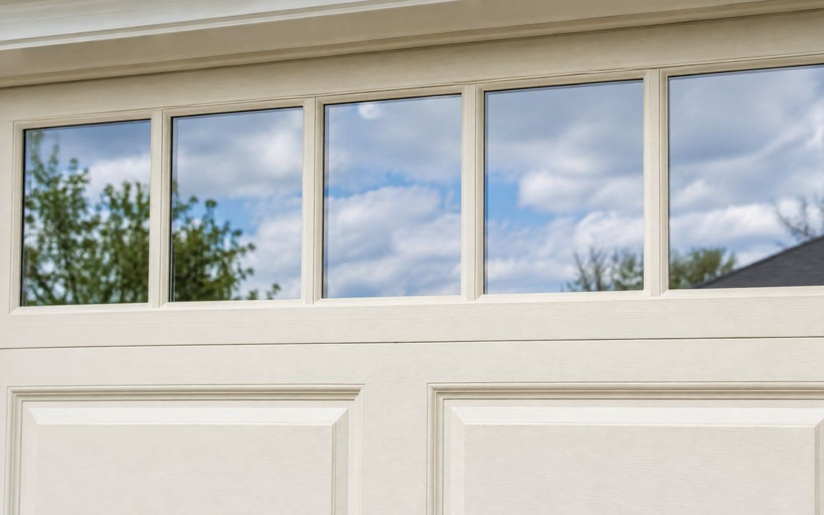 Glass panes set in wood across the top of a painted cream garage door.